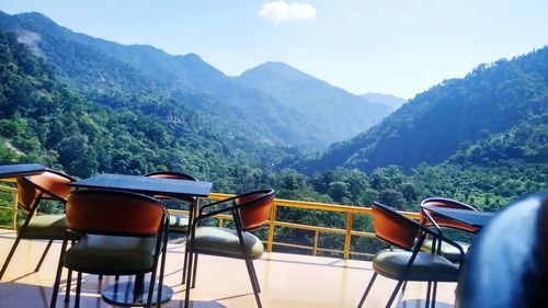 Chairs and mountains against sky