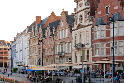 People on street against buildings in city