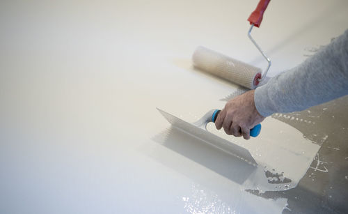 Close-up of person working on white wall
