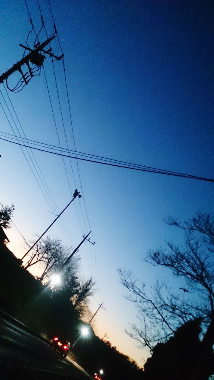 power line, low angle view, clear sky, cable, electricity pylon, electricity, power supply, silhouette, connection, blue, transportation, power cable, sky, dusk, street light, tree, outdoors, no people, technology, illuminated