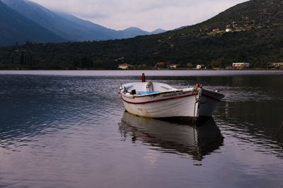 Boat moored on lake against sky