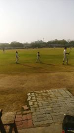 People on field against clear sky