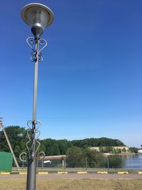 Low angle view of street light against blue sky