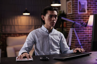 Portrait of young woman using laptop at table