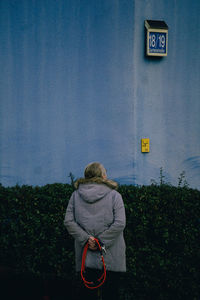 Rear view of woman standing by text against sky