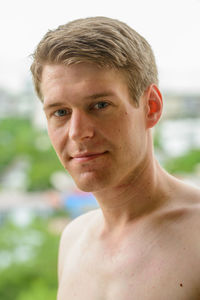 Close-up portrait of shirtless man smiling