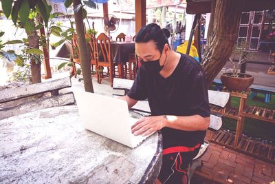 A man with a mask working on a marble table. because you need to keep your distance after the virus