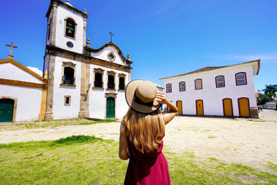 Young woman visiting the historic town of paraty unesco world heritage site, rio de janeiro, brazil.