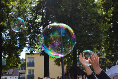 Low angle view of bubbles against rainbow in park