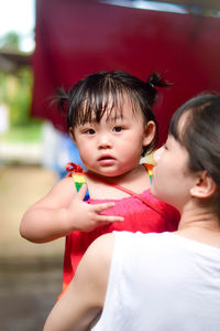 Close-up of mother carrying daughter