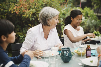 Happy family having meal at table in yard