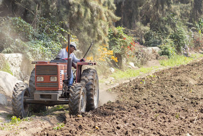 Farmer plowing field with tractor at farm