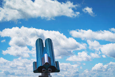 Low angle view of coin-operated binoculars against cloudy blue sky