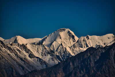 Scenic view of snowcapped mountains against blue sky