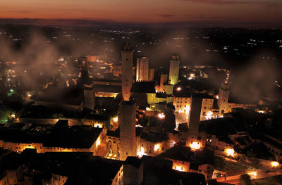 Night aerial view at sunset with fog of the medieval town of san gimignano tuscany