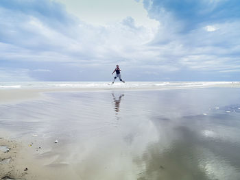 Man surfing in sea against sky