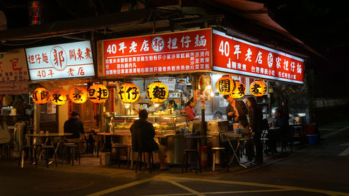 Illuminated sign on street in city at night