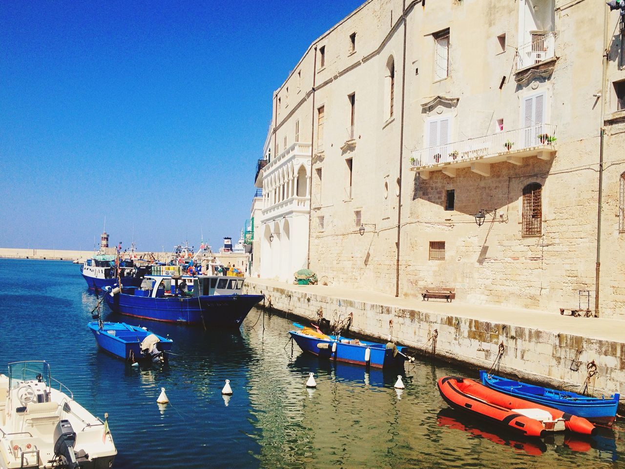 nautical vessel, water, boat, building exterior, moored, built structure, architecture, transportation, mode of transport, sea, clear sky, waterfront, blue, day, travel, outdoors, sky, no people, incidental people, residential building