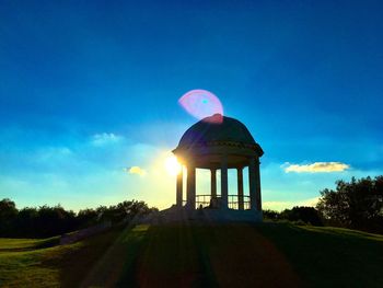 Built structure on field against blue sky