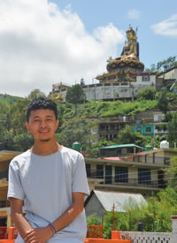 A tibetan guy standing against the beautiful hilly area of tso-pema and padmasambhava