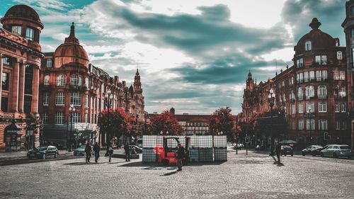 People on street in city against sky