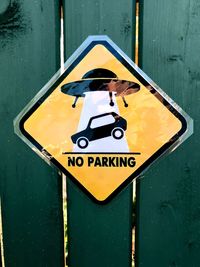 Close-up of road sign on fence