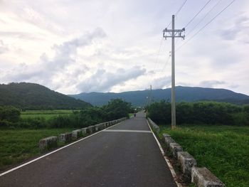 Road amidst field against sky