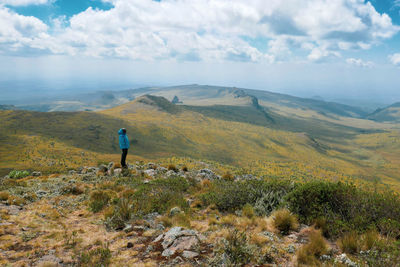 A hiker against a mountain background at the la satima dragons teeth in the aberdares, kenya