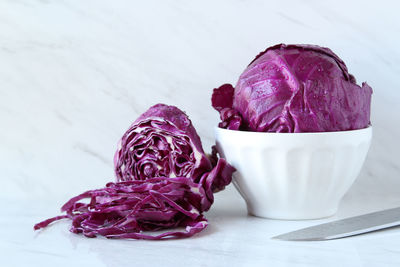 Close-up of red cabbages with bowl on marble