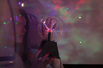 Midsection of person holding illuminated smart phone at night