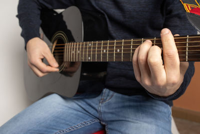 Midsection of man playing guitar