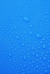 Full frame shot of water drops on blue surface