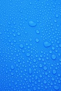 Full frame shot of water drops on blue surface