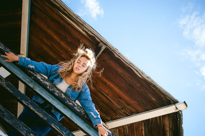 Low angle view of woman standing at observation point against sky