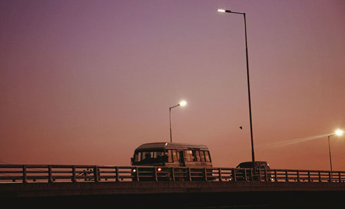 Illuminated bridge against sky at sunset
