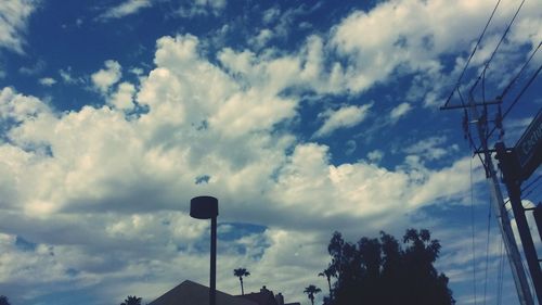 Low angle view of power lines against cloudy sky