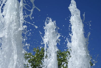 Close-up of frozen water against clear blue sky