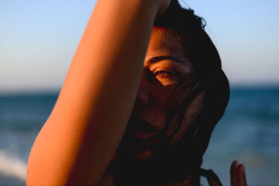 Close-up of young woman against sea