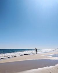 Man on beach against clear blue sky