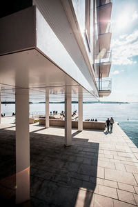 People at observation point by sea against sky