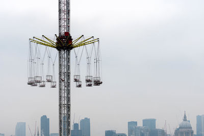 Low angle view of ferris wheel against buildings in city