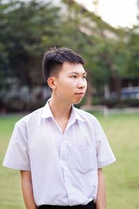 Portrait of young man standing against plants