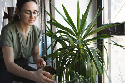 Florist woman watering and touching plants