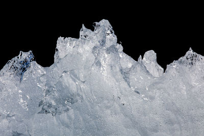 Close-up of snow on rock against black background