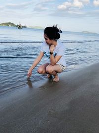 Young woman sitting on beach