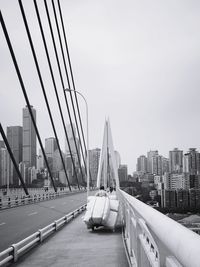 View of suspension bridge in city against sky