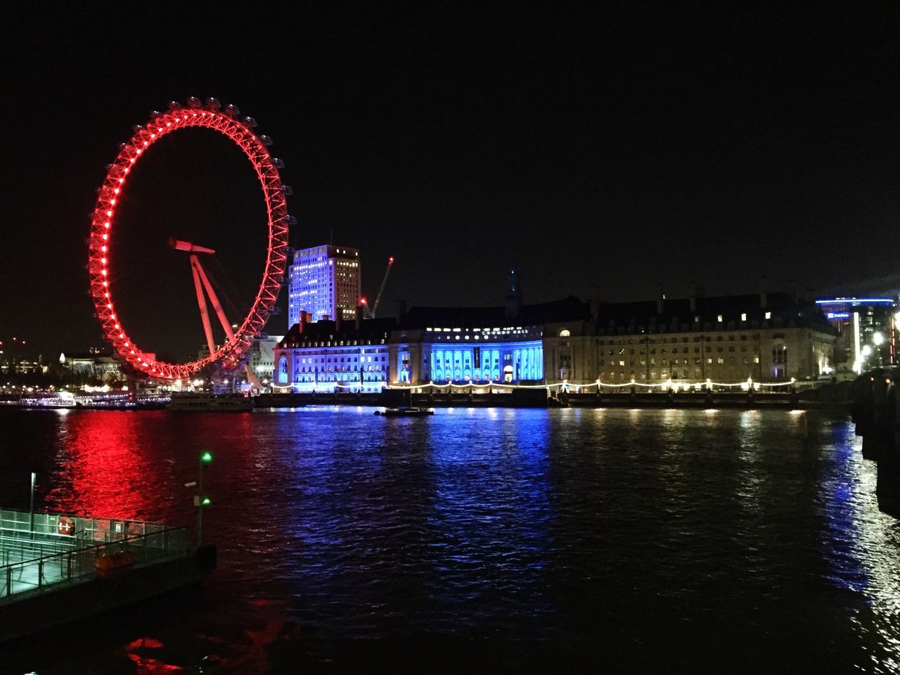 illuminated, night, architecture, built structure, building exterior, city, water, river, travel destinations, ferris wheel, famous place, waterfront, international landmark, capital cities, clear sky, tourism, travel, reflection, arts culture and entertainment, bridge - man made structure