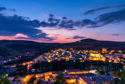 High angle shot of illuminated townscape against sky at sunset