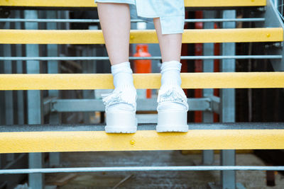 Low section of child standing on railing