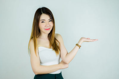 Portrait of a smiling young woman against white background